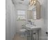 Compact bathroom featuring black and white tiled floor, a window for natural light, and classic fixtures at 3019 Sunset Dr, Charlotte, NC 28209