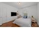 This cozy bedroom features hardwood floors, a mounted TV, and a window with bright natural light at 3019 Sunset Dr, Charlotte, NC 28209