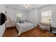 Bedroom featuring hardwood floors, natural light from two windows, and a dedicated workspace at 3019 Sunset Dr, Charlotte, NC 28209