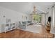 Bright living room featuring a vaulted ceiling, wood floors, a neutral color palette, and direct access to a patio at 3019 Sunset Dr, Charlotte, NC 28209