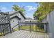 A backyard featuring lush green grass, a wooden fence, a utility shed, and elevated wooden deck at 313 Mayflower Ave, Cramerton, NC 28032