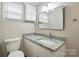 This bathroom is updated with modern fixtures, a granite countertop, vanity, and a large framed mirror at 313 Mayflower Ave, Cramerton, NC 28032