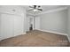 A bedroom showcasing neutral walls, carpet, ceiling fan, closet, and two entrance doors at 313 Mayflower Ave, Cramerton, NC 28032