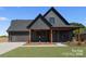 Stylish home with vertical siding, covered porch, green lawn, and attached two-car garage at 32531 Buchanan Ln, Albemarle, NC 28001
