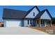 Charming single-story home with blue horizontal siding, stone accents, and attached two-car garage at 32531 Buchanan Ln, Albemarle, NC 28001