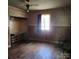 A bedroom shows hardwood floors, wood-paneled walls, and a window with a curtain at 40 Ranlo Ave, Gastonia, NC 28054