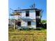 An old house is shown with scaffolding and missing windows, along with exterior damage at 40 Ranlo Ave, Gastonia, NC 28054