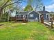 Exterior of home features blue siding, a spacious deck, and lush green yard with a wooden fence at 402 Sidney Johnson St, Fort Mill, SC 29715