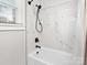 Bathroom with a bathtub and shower combination, marble-style tile, and black shower fixtures at 402 Sidney Johnson St, Fort Mill, SC 29715