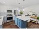 Well-lit kitchen with island, stainless appliances, blue lower cabinets and modern pendant lighting at 402 Sidney Johnson St, Fort Mill, SC 29715