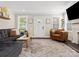 Well-lit living room boasts a gray sofa, leather chair, and white trim at 402 Sidney Johnson St, Fort Mill, SC 29715