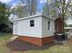 Backyard of a brick home featuring a white room addition and patio steps at 430 Coolidge Ave, Statesville, NC 28677