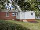 The exterior of this brick house features a mix of materials, including brick and white siding, surrounded by lush greenery at 430 Coolidge Ave, Statesville, NC 28677