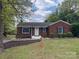 Charming brick home featuring a well-manicured front yard with mature trees and tasteful landscaping at 430 Coolidge Ave, Statesville, NC 28677
