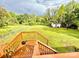 Backyard with wooden deck and stairs leading to a grassy fenced area at 45 Oak St, Great Falls, SC 29055