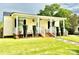 Inviting front porch with decorative hanging plants, white railing, and manicured greenery at 45 Oak St, Great Falls, SC 29055