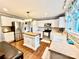 Well-lit kitchen featuring white cabinets, stainless steel appliances, an island, and mosaic backsplash at 45 Oak St, Great Falls, SC 29055