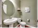 Stylish powder room with a pedestal sink, oval mirror, and wood-look floors at 4711 Pearmain Dr, Waxhaw, NC 28173