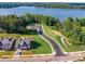 Aerial view of a lakefront community including a house, road, parking, and lake at 529 Cellini Pl # 243, Mount Holly, NC 28120