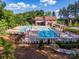Community pool with lounge chairs, picnic tables, and umbrellas surrounded by mature trees at 529 Cellini Pl # 243, Mount Holly, NC 28120