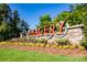 Community entrance sign set among a manicured landscape with vibrant flowers at 529 Cellini Pl # 243, Mount Holly, NC 28120