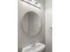 Clean bathroom featuring a modern oval mirror, sink, and vanity with a light fixture at 534 Donatello Ave, Charlotte, NC 28205