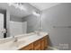Bathroom featuring double sinks, a wooden vanity, large mirror, and shower with tub at 534 Donatello Ave, Charlotte, NC 28205