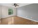 Bedroom with a window, ceiling fan, hardwood floors, and light gray and white walls at 534 Donatello Ave, Charlotte, NC 28205