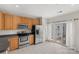 Well-lit kitchen featuring stainless steel appliances, wooden cabinets, and a door to a balcony at 534 Donatello Ave, Charlotte, NC 28205