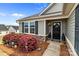 Inviting front porch with black door, stone accents, landscaping, and colorful decorations at 550 Cherry Blossom Nw Ave, Concord, NC 28027