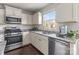Bright kitchen featuring white cabinets, stainless steel appliances, and granite countertops at 550 Cherry Blossom Nw Ave, Concord, NC 28027