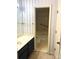 Bathroom features vanity, tub and shower combo with sliding glass doors, and decorative wallpaper at 5810 Harris Grove Ln, Charlotte, NC 28212