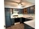 A vintage kitchen features painted cabinetry, a brick floor, and solid surface counters at 5810 Harris Grove Ln, Charlotte, NC 28212