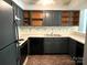 A vintage kitchen features painted cabinetry, a brick floor, and solid surface counters at 5810 Harris Grove Ln, Charlotte, NC 28212