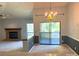 Open layout with a fireplace, dining area with chandelier, and sliding glass door access to the balcony at 5810 Harris Grove Ln, Charlotte, NC 28212
