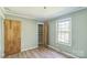 Bright bedroom features a closet with shelving, a window, light-green walls, and wood-look flooring at 5944 Freedom Dr, Charlotte, NC 28214