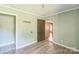 Bright bedroom with wood-look floors, featuring neutral-toned walls, and two doorways for easy access at 5944 Freedom Dr, Charlotte, NC 28214
