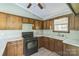 Functional kitchen featuring wood cabinets, basic appliances, and a bright window overlooking the outside at 5944 Freedom Dr, Charlotte, NC 28214