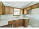 This kitchen has wood cabinets and a double basin sink; a window provides natural light and backyard views at 5944 Freedom Dr, Charlotte, NC 28214