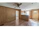 Spacious living area with wood paneling, laminate flooring, and open access to the kitchen and hallway at 5944 Freedom Dr, Charlotte, NC 28214
