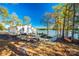 Lakefront backyard with a patio, lush landscaping, and a serene waterfront view at 6788 Bucleigh Rd, Clover, SC 29710