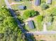 An aerial view displays a home with a dark roof surrounded by green trees and neighboring properties at 692 S Pink St, Cherryville, NC 28021