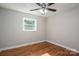 Comfortable bedroom features hardwood floors, neutral paint, a ceiling fan, and a bright window at 692 S Pink St, Cherryville, NC 28021