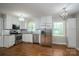 Well-lit kitchen with stainless steel appliances, white cabinetry, granite counters, and hardwood flooring at 692 S Pink St, Cherryville, NC 28021