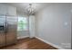 Bright eat-in kitchen featuring stainless steel refrigerator, custom cabinets, and stylish modern lighting at 692 S Pink St, Cherryville, NC 28021