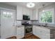 Charming kitchen features white cabinets, stainless steel appliances, granite countertops, and stylish backsplash at 692 S Pink St, Cherryville, NC 28021