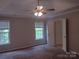 Serene bedroom with a ceiling fan, plush carpet, and abundant natural light from large windows at 7731 Harrington Woods Rd # 17, Charlotte, NC 28269