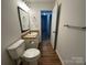 Bathroom with a toilet, vanity, wood grain floors, and a mirror at 8829 Michaw Ct, Charlotte, NC 28269
