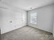 Clean bedroom with carpet, door, and large window for natural light at 8829 Michaw Ct, Charlotte, NC 28269