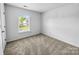 Carpeted bedroom with a window overlooking the neighborhood at 8829 Michaw Ct, Charlotte, NC 28269